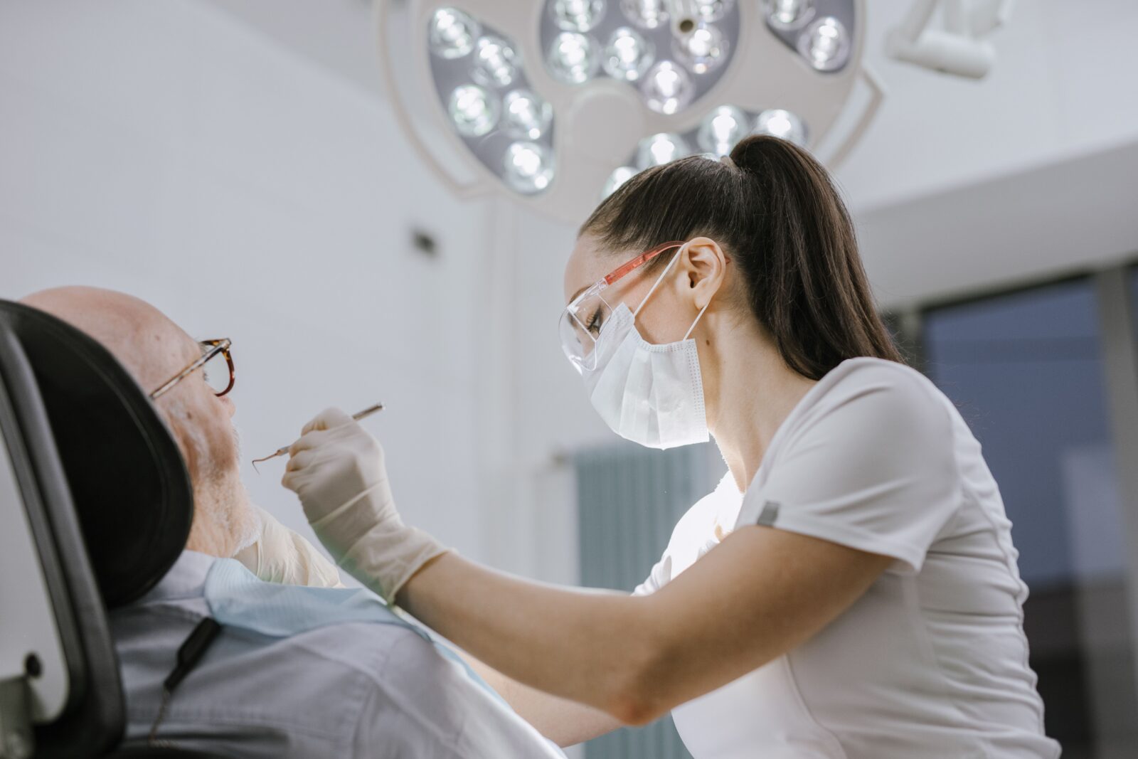 http://Female%20dentist%20working%20on%20a%20patient%20in%20a%20modern%20dental%20office%20with%20bright%20lighting.
